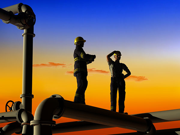 Travailleurs sur une structure industrielle au coucher du soleil